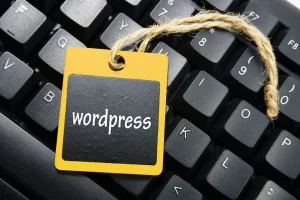Tag with "wordpress" written on it laying on a keyboard